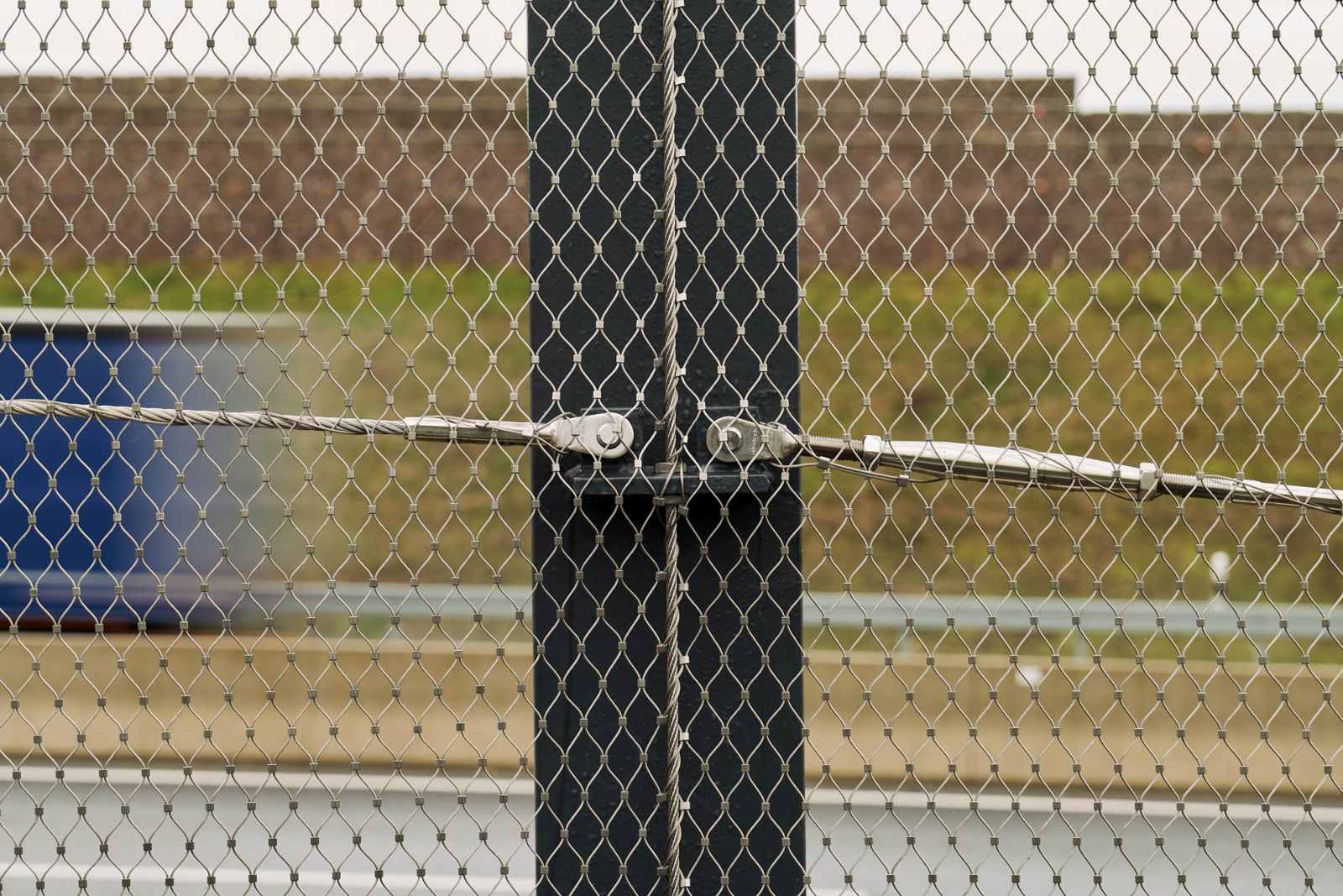 Two turnbuckles and guy ropes of the stainless steel cable mesh fence