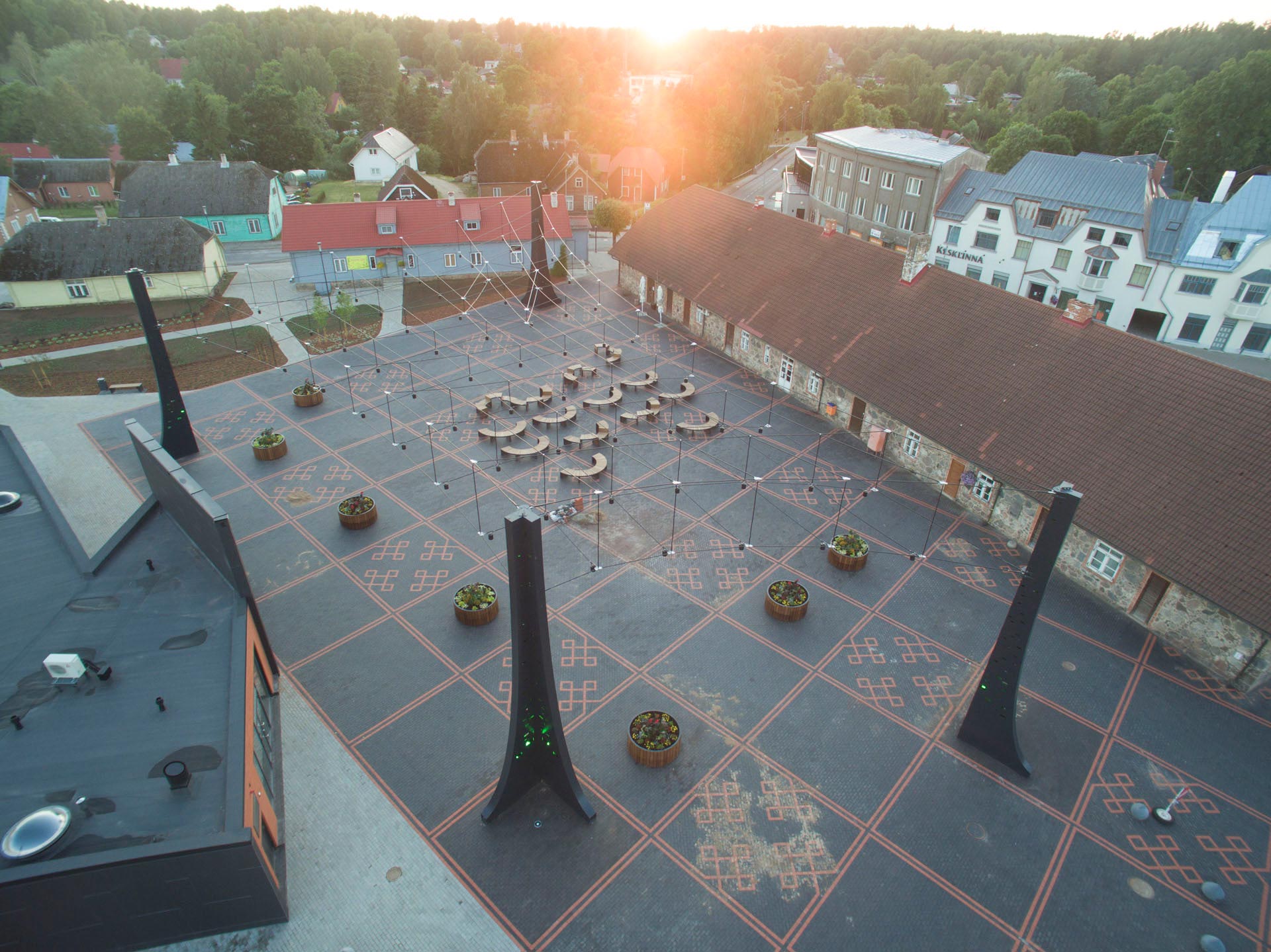 Torva centre square with four steel pylones holding a lamp suspension at sunset