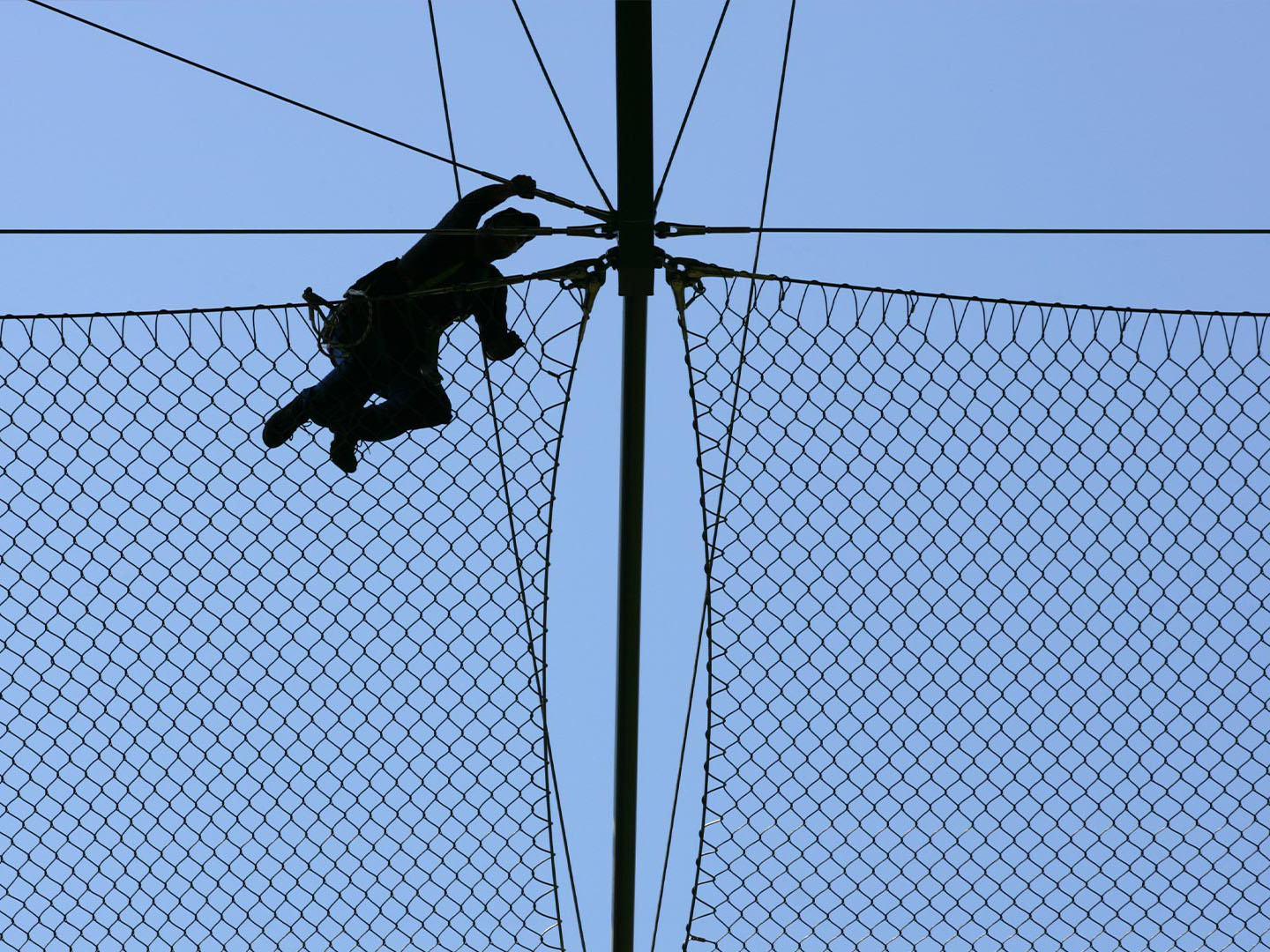 A worker installing a horizontal Webnet safety seen from below