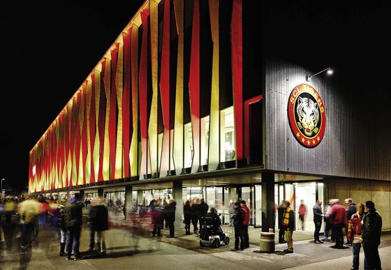 The facade Ilfishalle in Langnau at night illuminated in red and yellow, the colors of the SCL Tigers