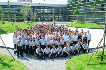 Group image of staff and team of Jakob Saigon and architects in the courtyard of the factory