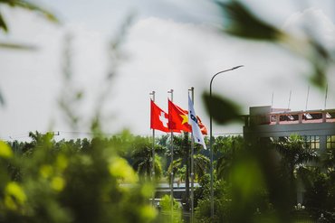 The flags of Switzerland, Vietnam and Jakob Saigon flying in the wind