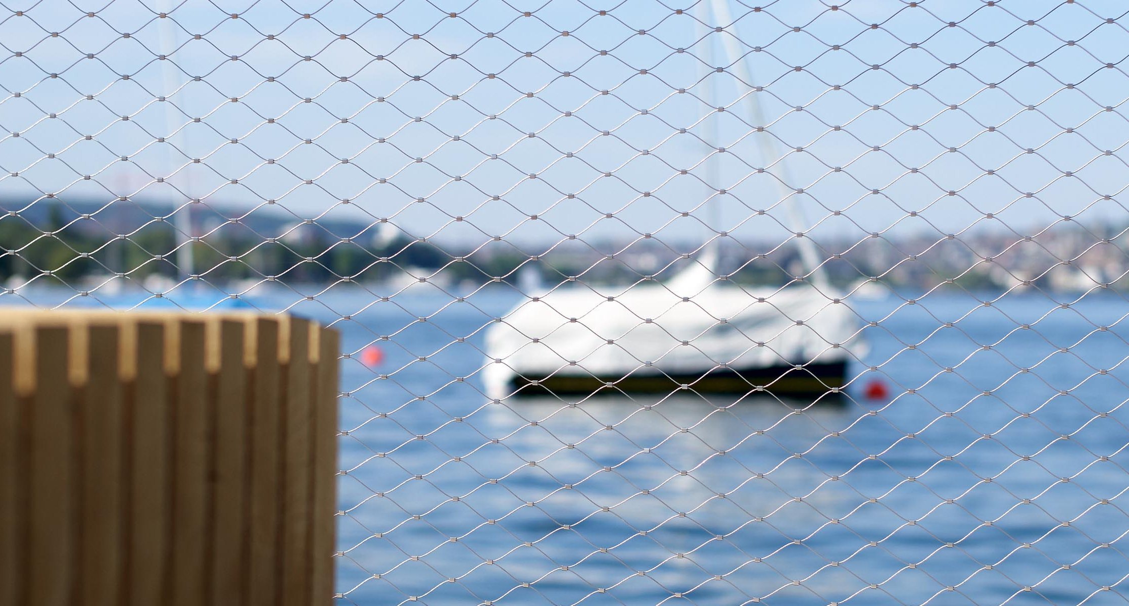 Das Edelstahlnetz Webnet am Zürichsee mit einem Boot im Hintergrund